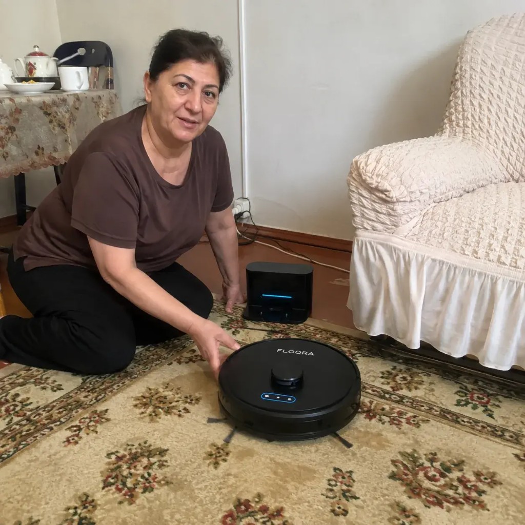 Cliente Floora a casa con robot aspirapolvere sul tappeto